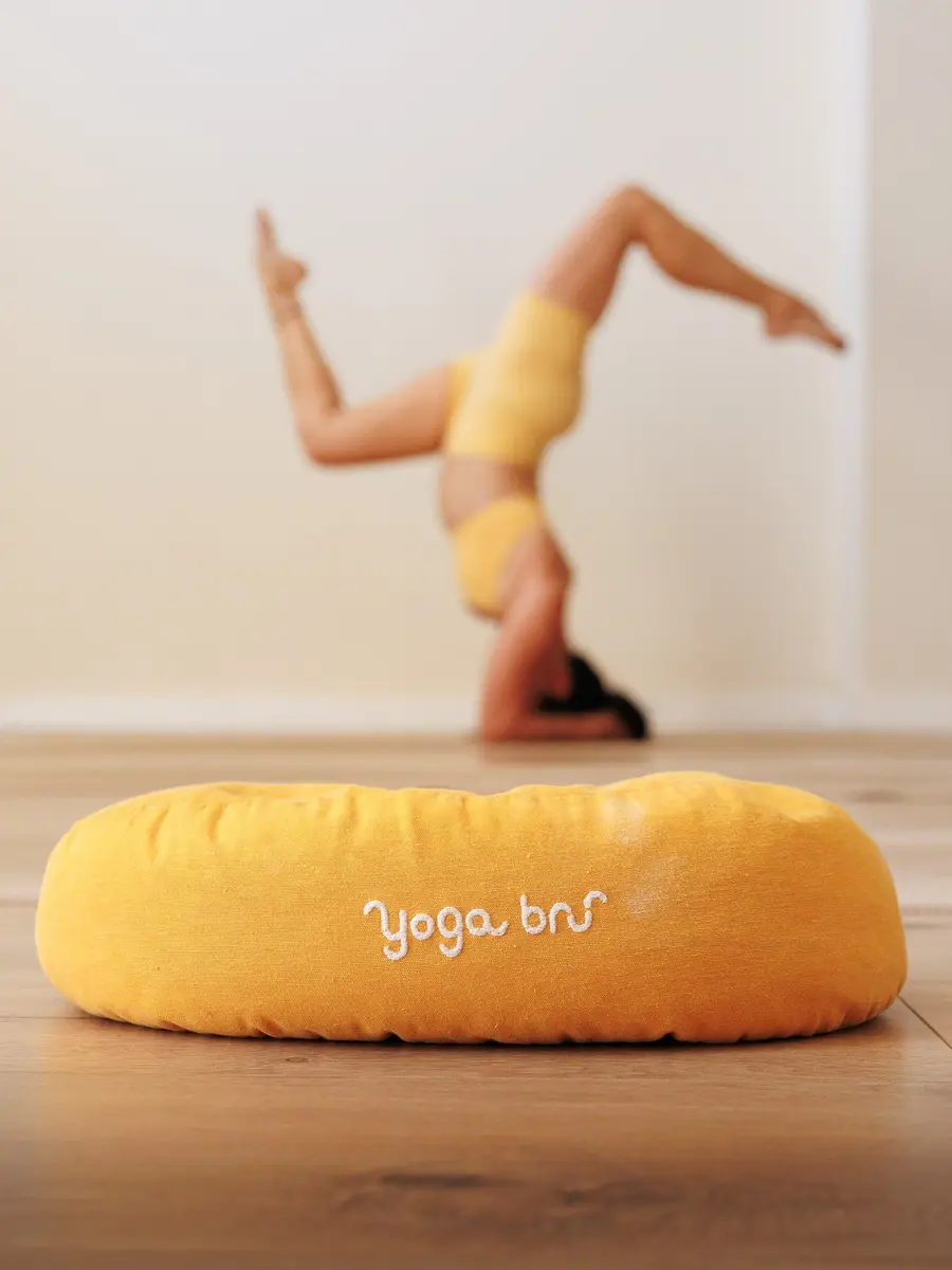 Equilibrio invertido junto a un cojín amarillo